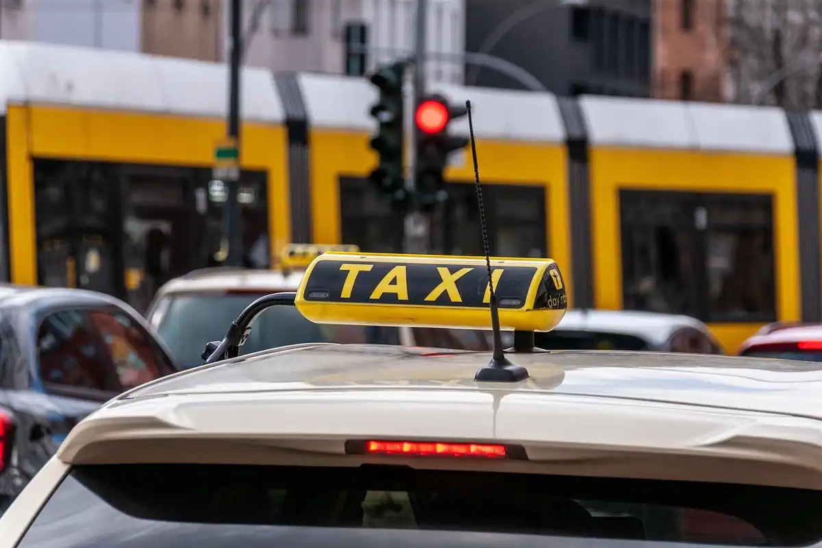 Semn de circulație pe o stradă din oraș, cu mașini care trec prin trafic în fundal