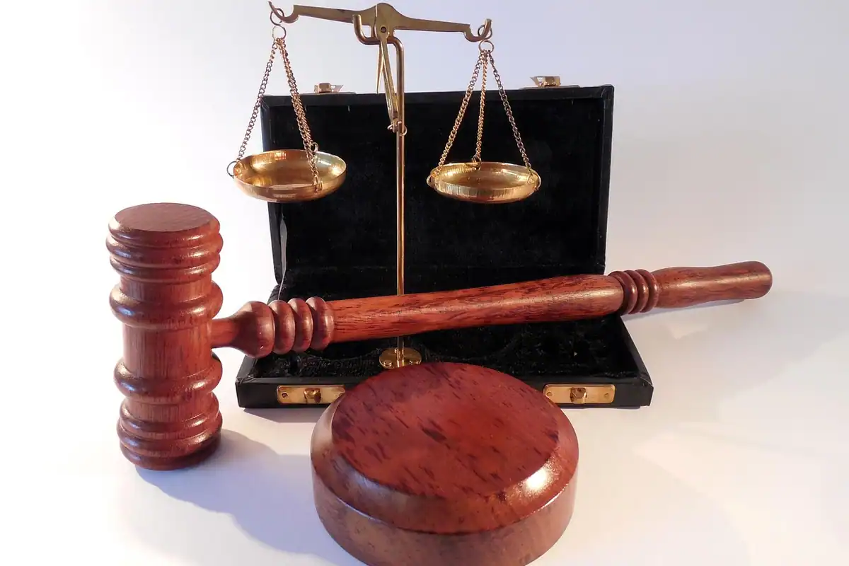 Ciocan de judecător și balanță a justiției pe un birou din lemn