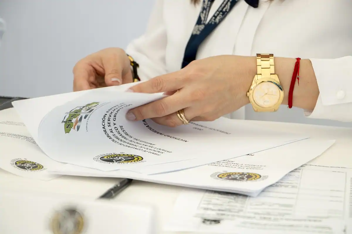 Persoană cu ochelari care citește atent un contract tipărit, așezată la birou