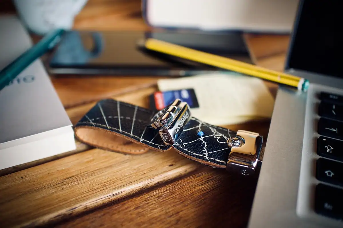 Stick USB conectat la un laptop așezat pe un birou, pentru copierea datelor