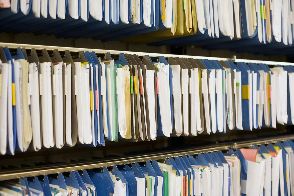 Rafturi cu dosare colorate dintr-o arhivă de documente