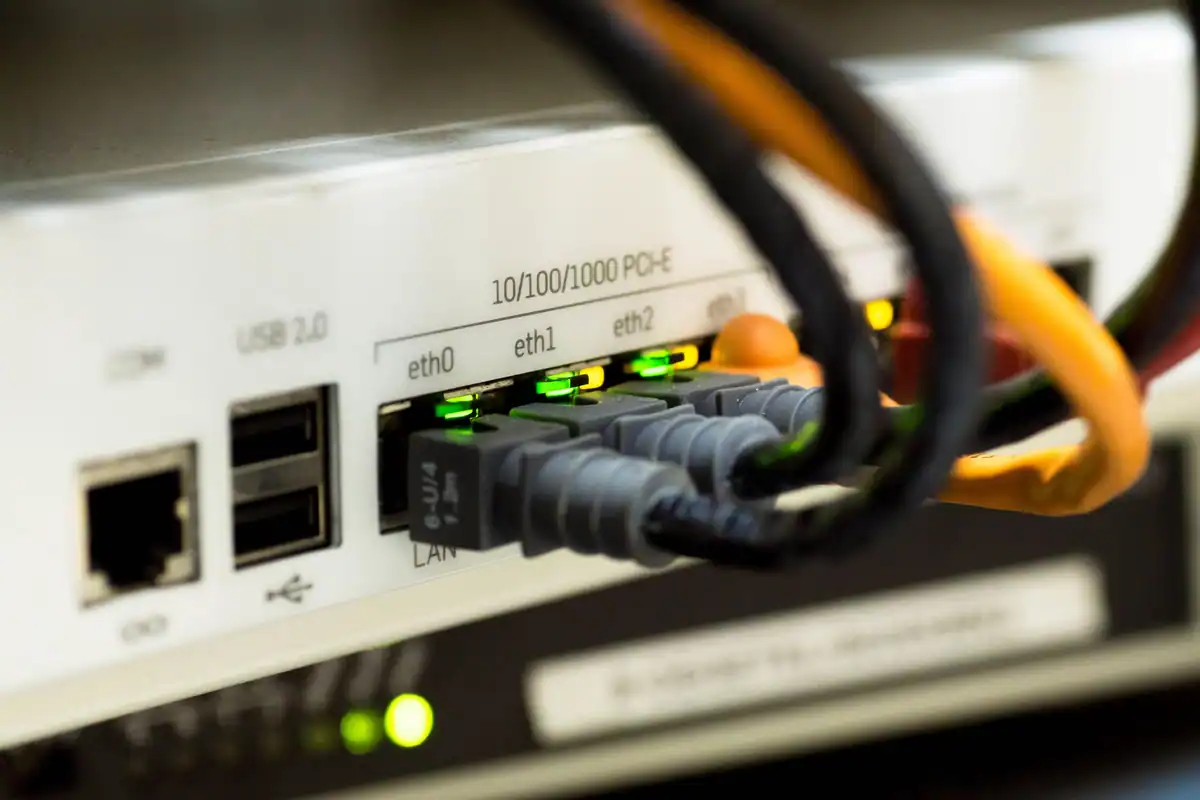Router cu cabluri de rețea conectate în porturi, fotografiat de aproape