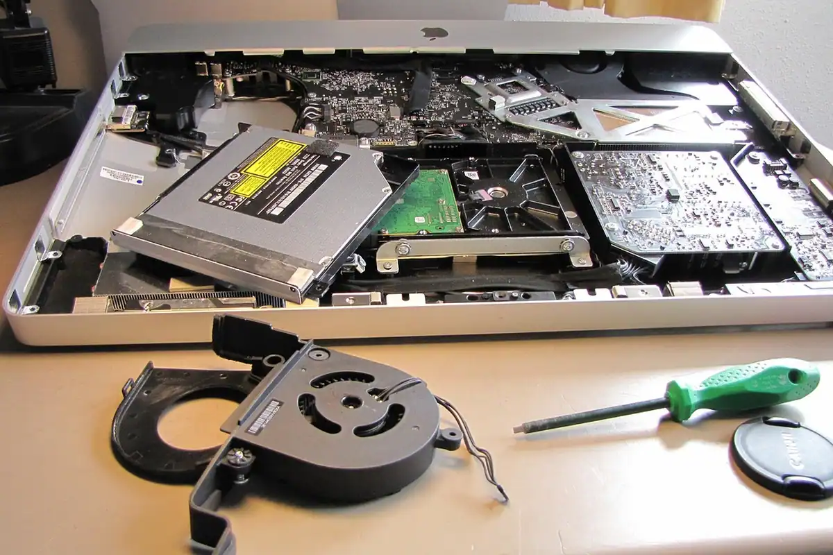 Laptop deschis pe un banc de lucru dintr-un service, pregătit pentru reparație