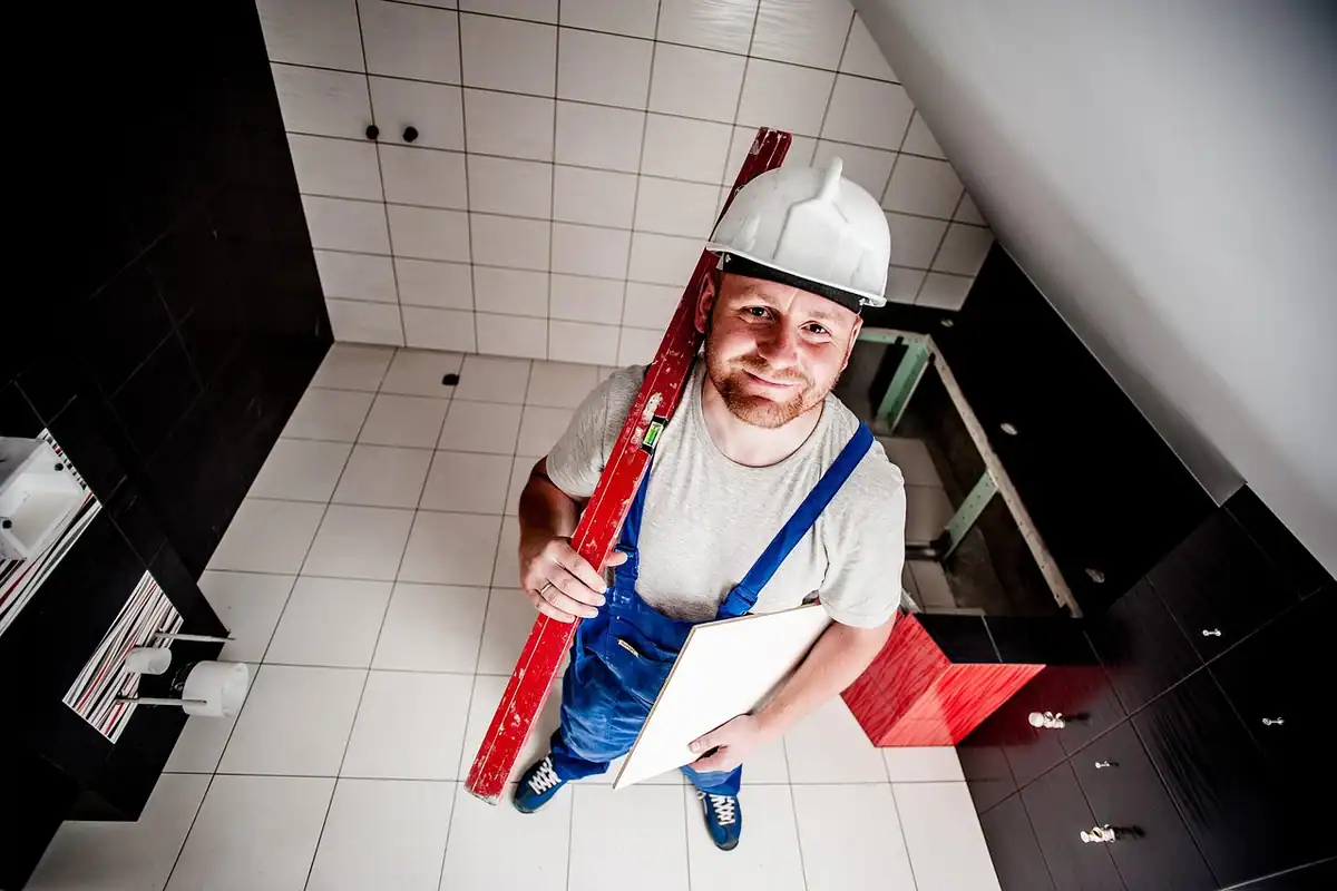 Meșter care repară un perete cu ajutorul uneltelor, într-o lucrare de renovare